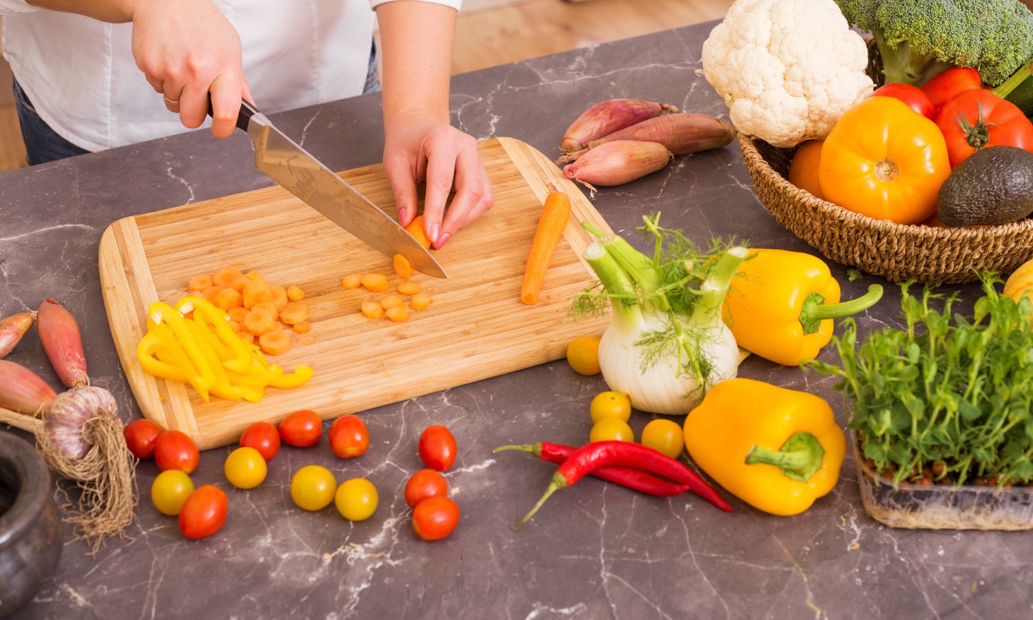 hands chopping a fresh carrot