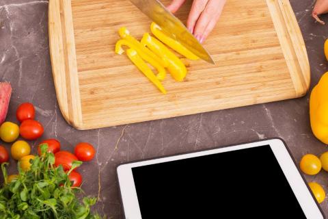 Chopping vegetables beside a tablet
